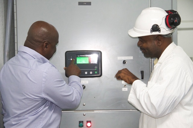 Hon. Alexis Jeffers, Minister of Communications, Works and Public Utilities (right) with Ivan Weekes, operator in the Generation Department at the controls commissioning the MP36 2.5megawatt generating set at Prospect Power Plant on December 21, 2016